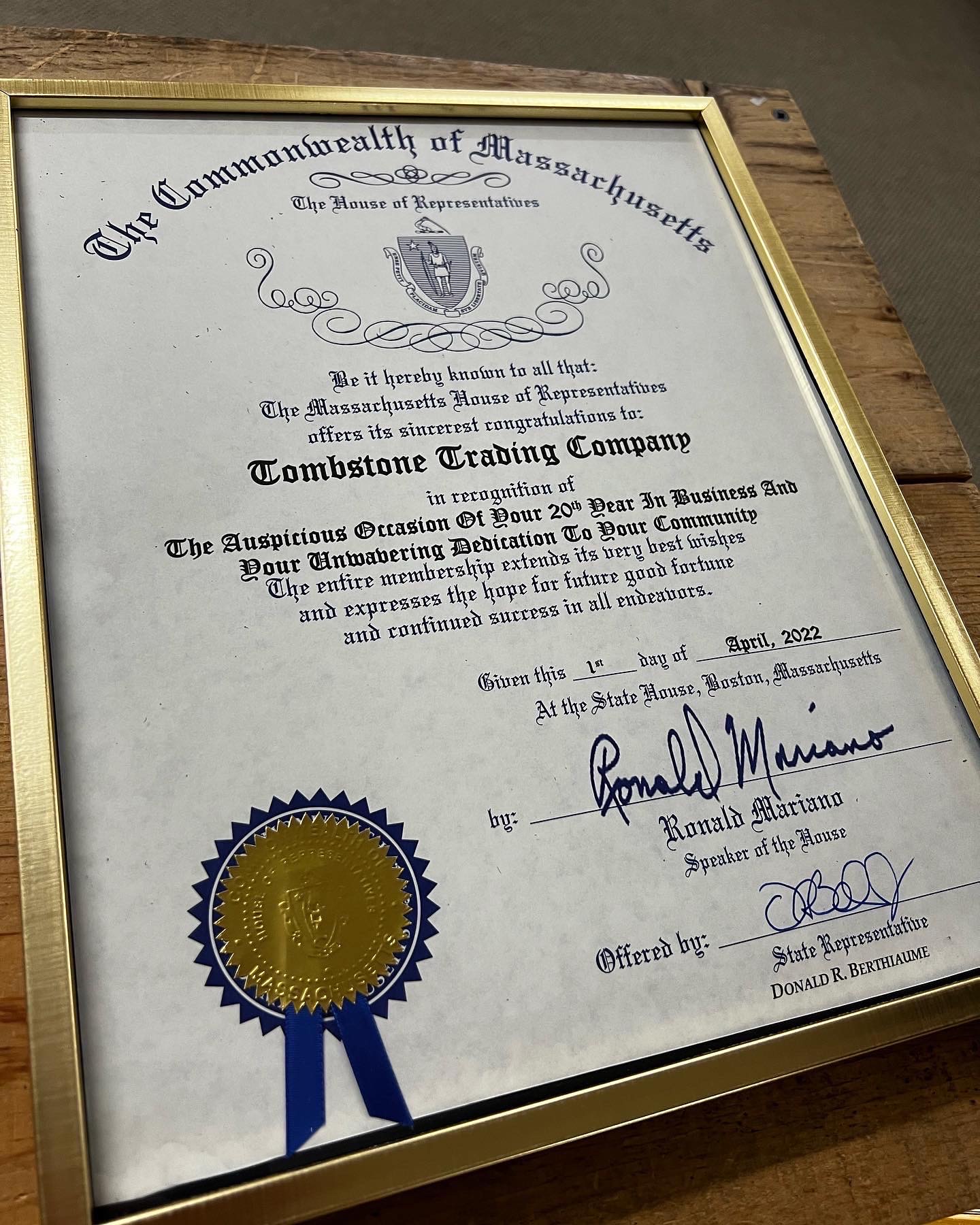 State Rep Donnie Berthiaume presents a certificate recognizing Tombstone Trading Company's 20th year in business.
